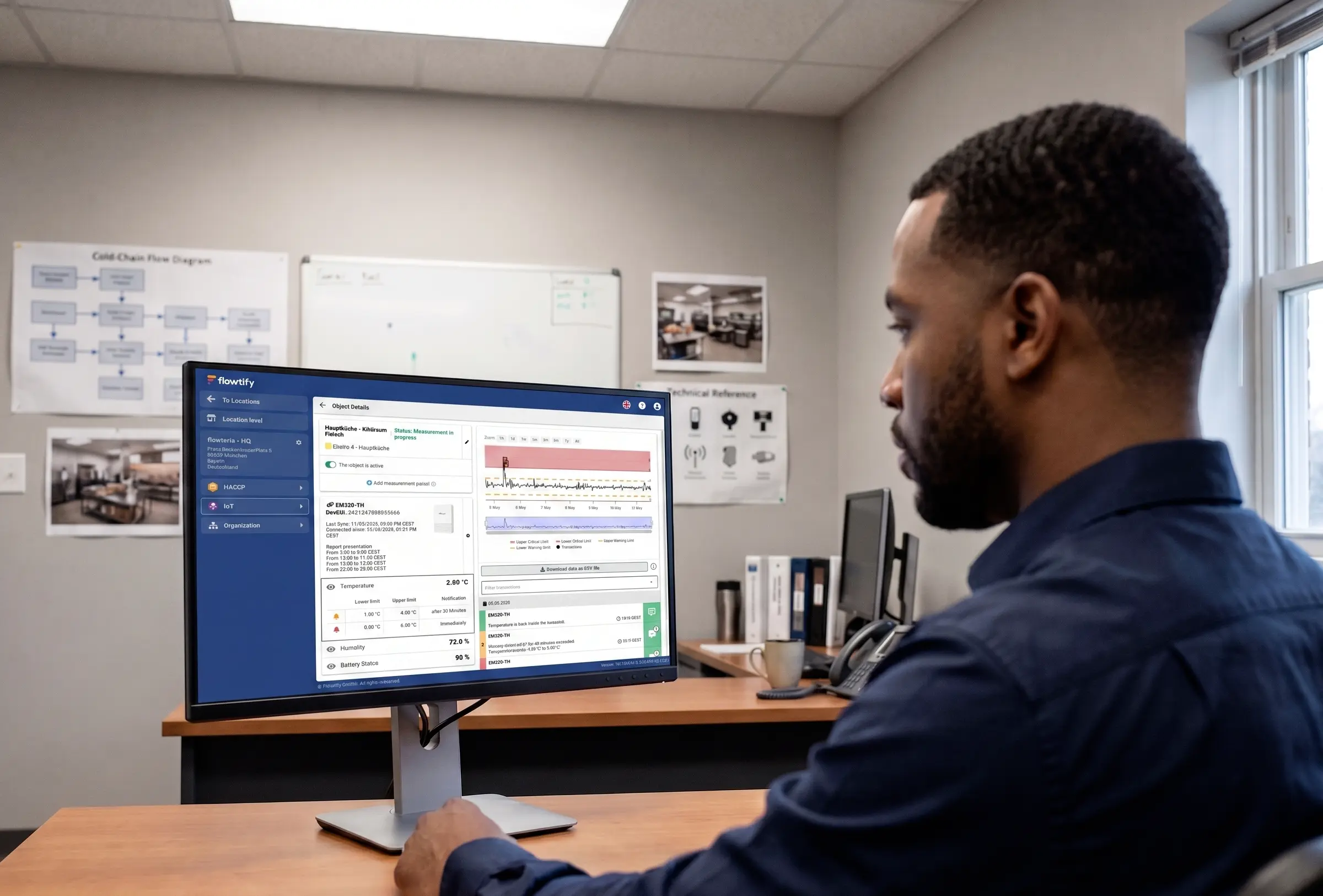 Quality manager in an office analyzing the temperature curve of a refrigeration unit on a desktop monitor in the flowtify IoT detail view: recurring fluctuations over several days, threshold limits, and alert history are visible as the basis for evaluating equipment stability.